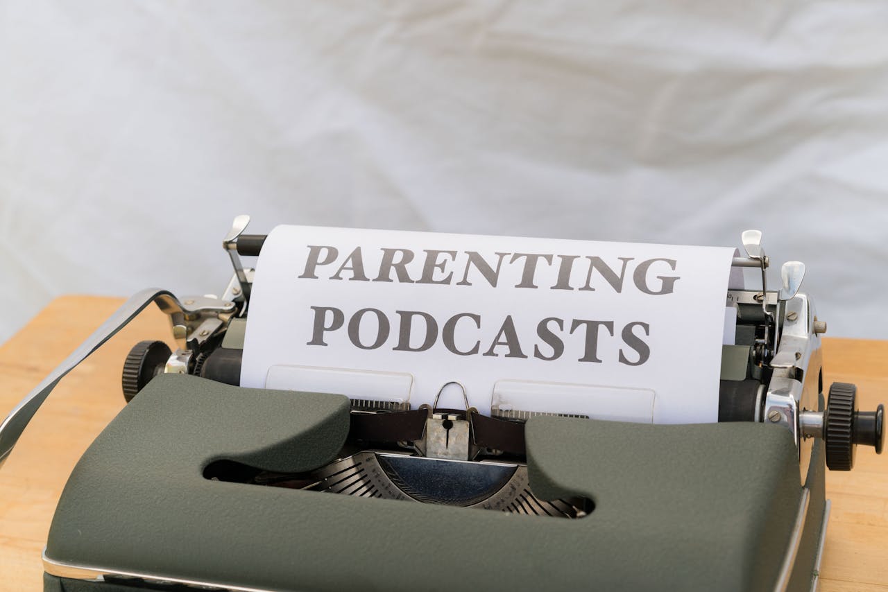 A classic typewriter with a sheet labeled Parenting Podcasts set against a neutral background.